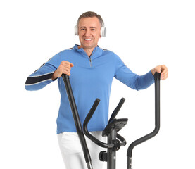 Sporty mature man in headphones on exercising bike against white background