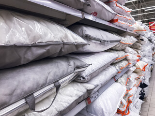 Pillows in the store White for sleeping ,stacked on the shelf of a bedding store .concept Sleep Products