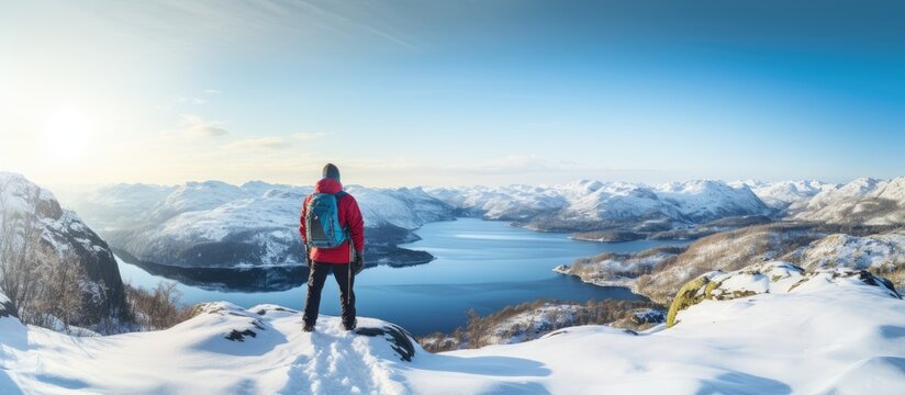 back view of tourist with backpack hiking in winter in Norway one man carrying backpack in a Norwegian winter landscape. Copy space image. Place for adding text or design
