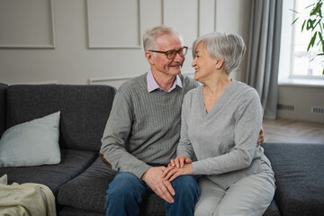 Senior adult mature couple hugging at home. Mid age old husband and wife embracing with tenderness love enjoying sweet bonding wellbeing. Grandmother grandfather together. Family moment love and care
