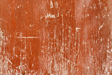 A rich, red wooden surface bears the beautiful marks of time and weather, offering a textured...