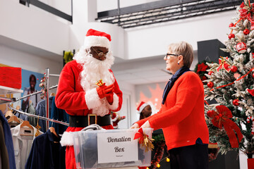 People filling out boxes for gifts to assist Santa Claus worker distribute Christmas spirit and...