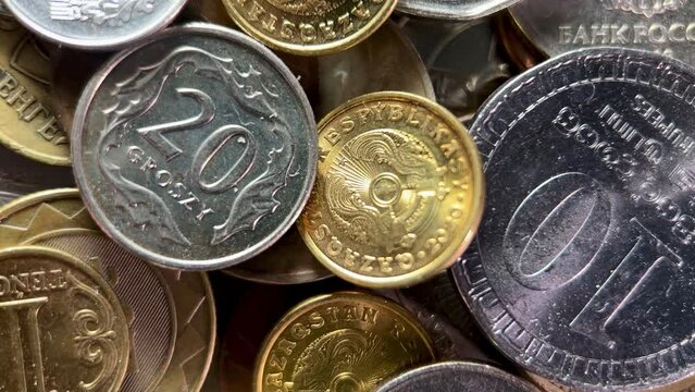 A close-up image showing a diverse collection of international coins in various denominations and metals, symbolizing global currency and economy