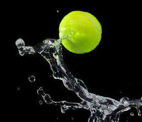 Tennis ball hit water and splash in air. Green Tennis ball fly in rain and splatter spin splash in...