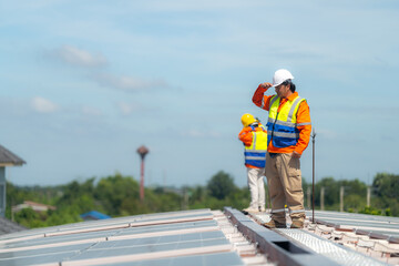 Engineer man is working to construct solar panels system on roof. Installing solar photovoltaic panel system. Alternative energy ecological concept. Renewable clean energy technology concept.