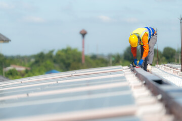 Engineer man is working to construct solar panels system on roof. Installing solar photovoltaic...