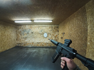 Shooting from an M4 rifle at a shooting range at targets, first-person photo from an action camera.