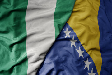 big waving national colorful flag of bosnia and herzegovina and national flag of nigeria .