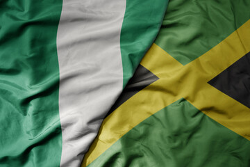 big waving national colorful flag of jamaica and national flag of nigeria .