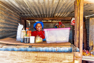 Obraz na płótnie Canvas african woman selling potato chips in a shack in a village, Street Vendors and Market Traders in Africa, an entrepreneurial occupation numerous personal, cultural, 