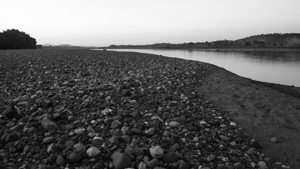 Black and white photograph of the sandy and stony coast of one of the rivers in Tinapuay, Banga, Aklan, Philippines. - Powered by Adobe