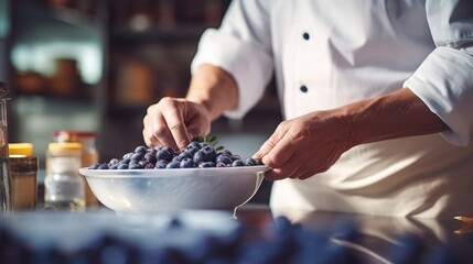 Fototapeta premium Culinary Artistry: A Close-Up of a Chef Preparing Blueberries in a Professional Kitchen
