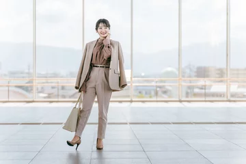 Foto op Plexiglas ビジネスウーマン・ファッションモデルの女性（都会・公共施設・空港・駅・全身）  © buritora