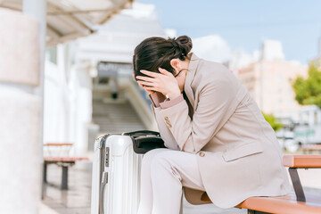 駅・旅行中に体調不良になったビジネスウーマン
