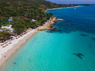 Fototapeta premium Koh Samet Island Thailand, aerial drone view from above at the Samed Island in Thailand with a turqouse colored ocean and a white tropical beach with beach chairs and umbrellas