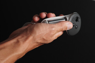 Close-up of hands changing battery in wireless joystick for VR headset.