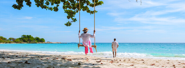 A couple of men and women at a swing on the beach of Koh Samet Island Rayong Thailand, a couple on honeymoon in Thailand - obrazy, fototapety, plakaty