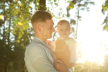 Father with his cute daughter spending time together in park on summer day