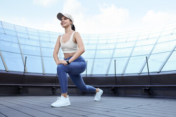 Beautiful woman in stylish sportswear doing exercises outdoors. Space for text - Powered by Adobe
