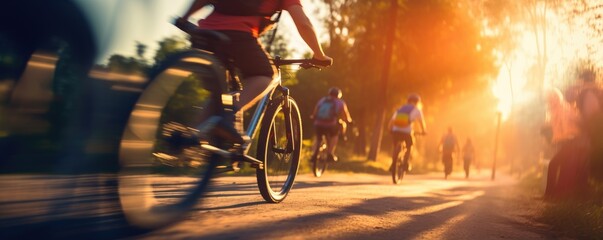 Cyclists riding a bike on a trail outdoors at golden hour - obrazy, fototapety, plakaty
