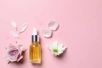 Bottle of cosmetic serum and beautiful flowers on pink background, flat lay. Space for text
