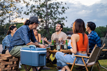 Group of diverse friend having outdoors camping party together in tent. 