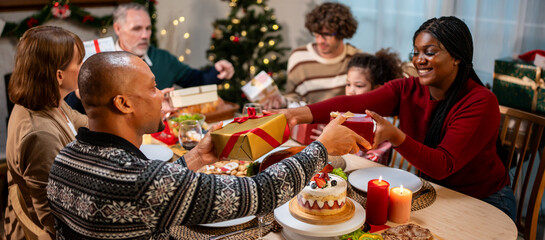 Multi-ethnic family exchanging presents during Christmas party at home. 