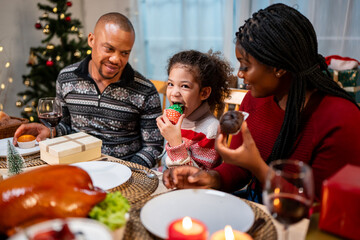 African American family celebrating Christmas party together in house. 