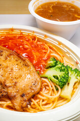 angle view chicken cutlet with tomato and meat sauce pasta and bowl of crab roe flavored soup at vertical composition