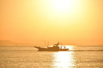 朝日の中漁場へ向かう漁船