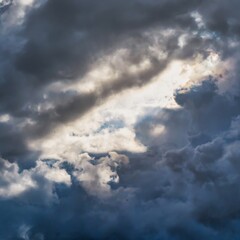 Menthon saint Bernard, France - September 22 2020 : a thick gray blue cloud formation and the sun behind trying to get through