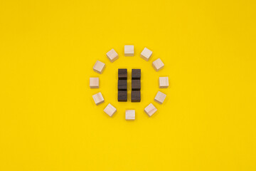 ウッドキューブの丸いアイコンの停止ボタンが中央にある黄色い背景