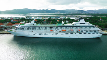 Aerial view of a huge cruise ship waiting to depart at a port on a tropical island. Vacation on a...