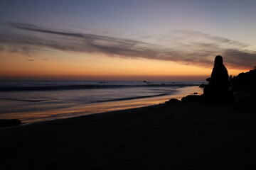 Woman watching sunset on the beach