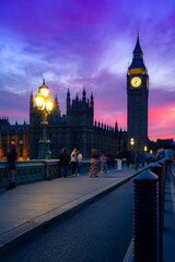 Exterior of historic buildings with glowing lights located against Big Ben tower at night in London...