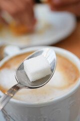 dropping sugar cube in a coffee cup ,