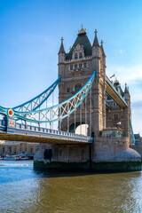 Fototapeta na wymiar Amazing view of Tower bridge with flags over rippling river against cloudy blue sky in London