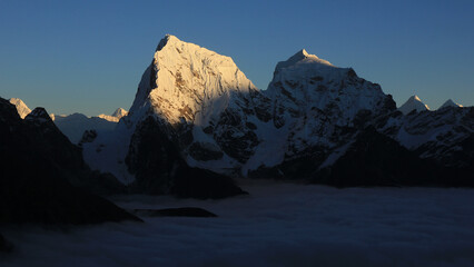 Fototapeta premium Sun lit peak of Mount Cholatse at sunset, Nepal.