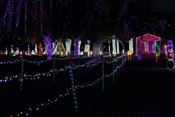 Landscape texture background of colorful holiday lights, with a walkway to a covered bridge