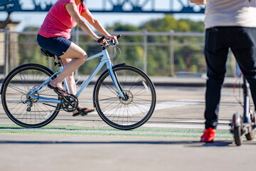 An elderly woman prefers cycling and outdoor exercise to maintain health and the whole body in good shape rather than riding an electric scooter