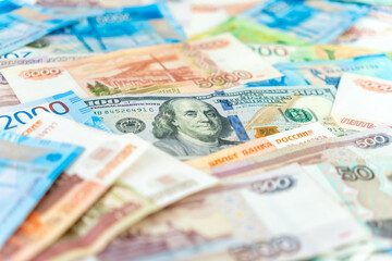 One hundred dollar bill under some five thousand ruble banknotes. currency exchange concept. Close up.