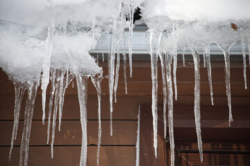 Large icicles hanging from the edge of a roof