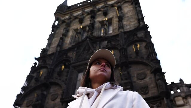 Girl stand near impressive gothic style Powder Gate building exterior