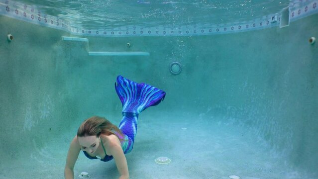 Underwater swim in a pool with a mermaid as she blows kisses and air bubbles