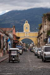 The Santa Catalina Arch rises above a quaint cobblestone street in Antigua, Guatemala.