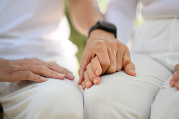 Closeup retired senior couple holding hands symbolizing supporting, empathy and understanding.