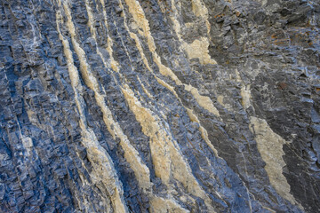 Fototapeta premium Swirling color in light and dark in a natural rock formation, cream colored and dark gray, as a nature background 