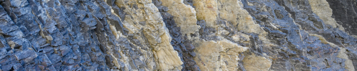 Fototapeta premium Swirling color in light and dark in a natural rock formation, cream colored and dark gray, as a nature background 