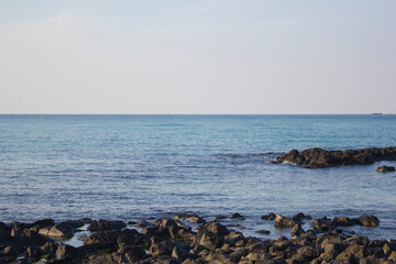 
This is a Jeju Island beach with basalt rocks. - obrazy, fototapety, plakaty