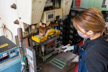 工場で機械を使い、働く女性 - obrazy, fototapety, plakaty